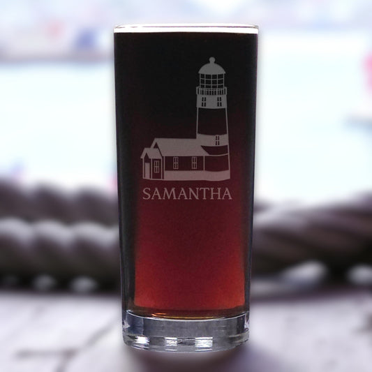 Pint glass with lighthouse design and 'Samantha' text on a blurred background