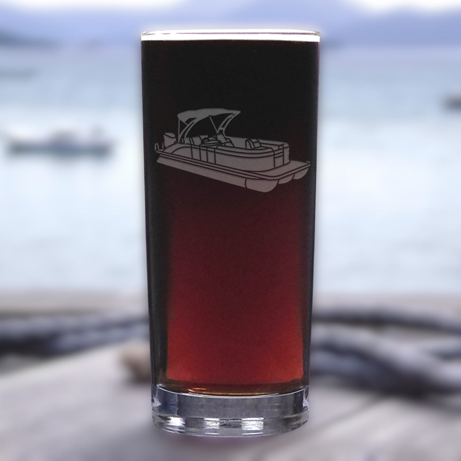 Glass with a boat engraving on a blurred water background