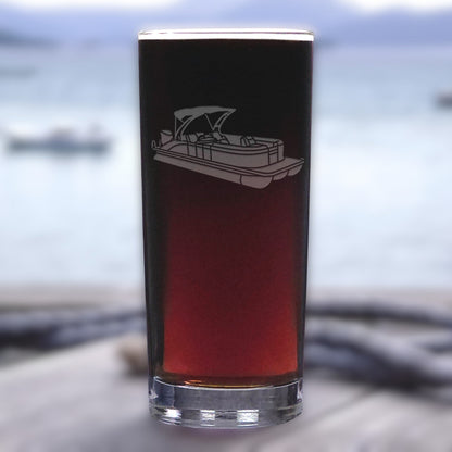Glass with a boat engraving on a blurred water background