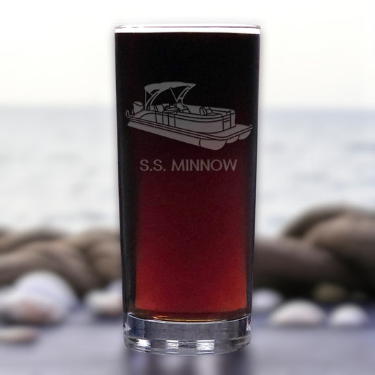 Glass with 'S.S. Minnow' engraving on a blurred natural background
