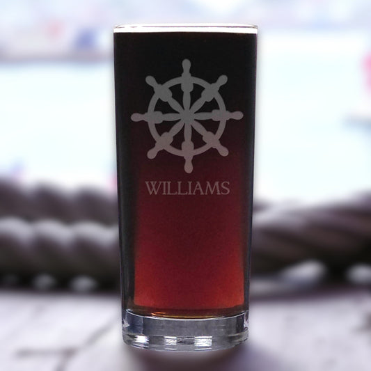 Personalized glass with a wheel design and 'Williams' text on a blurred background