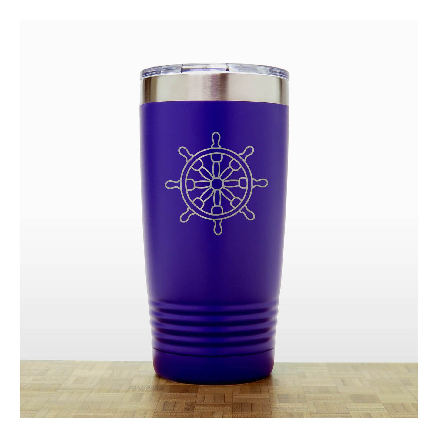 Purple tumbler with a white ship's wheel design on a wooden surface.