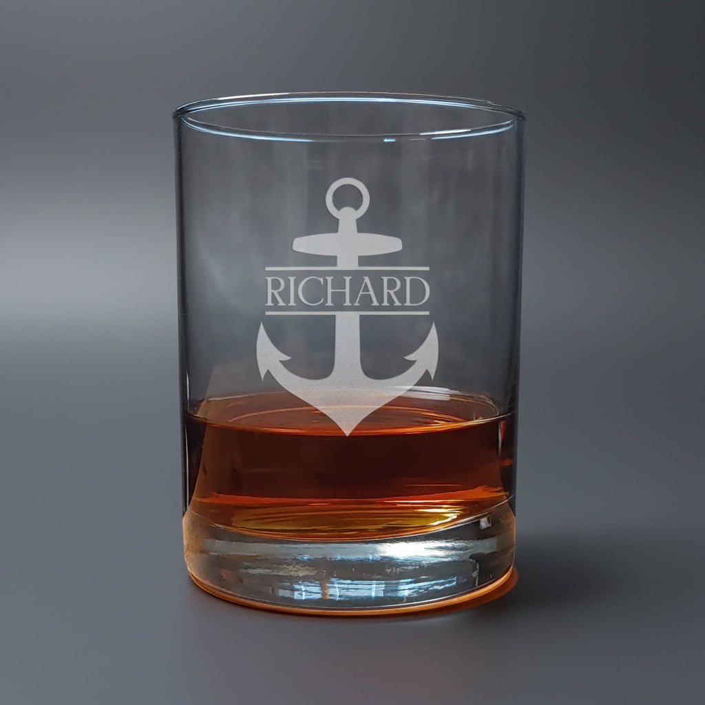Clear glass tumbler with anchor design and 'Richard' text, filled with a brown liquid 
