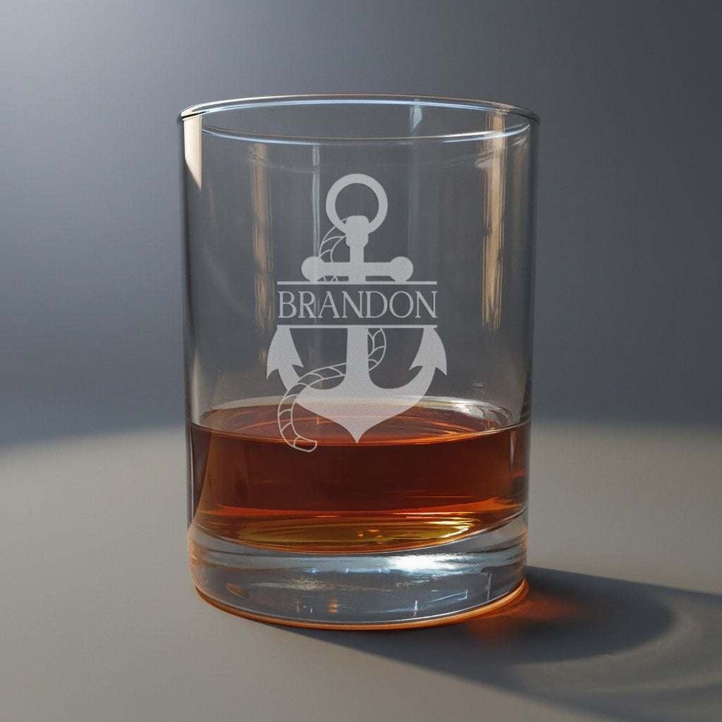 Clear glass tumbler with engraved anchor design and 'Brandon' text, filled with amber liquid.