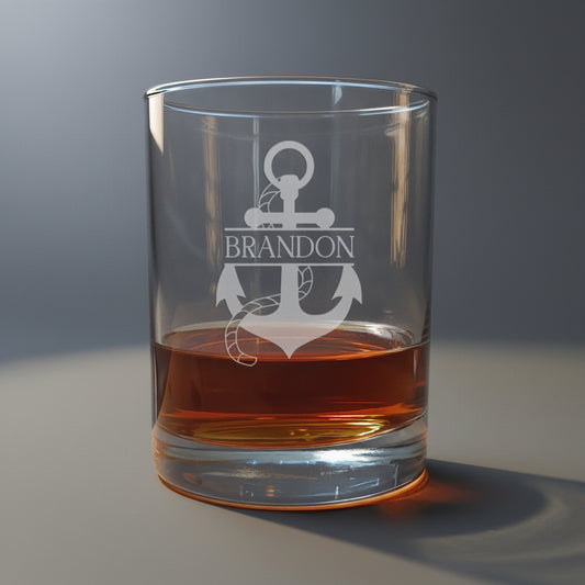 Clear glass tumbler with engraved anchor design and 'Brandon' text, filled with amber liquid.