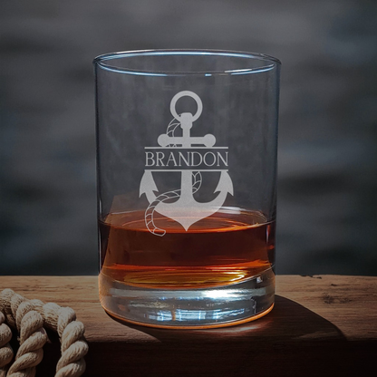 Clear glass with anchor design and 'Brandon' text, filled with amber liquid on a wooden surface.