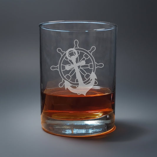 Clear glass with ship's wheel and anchor design, filled with amber liquid 