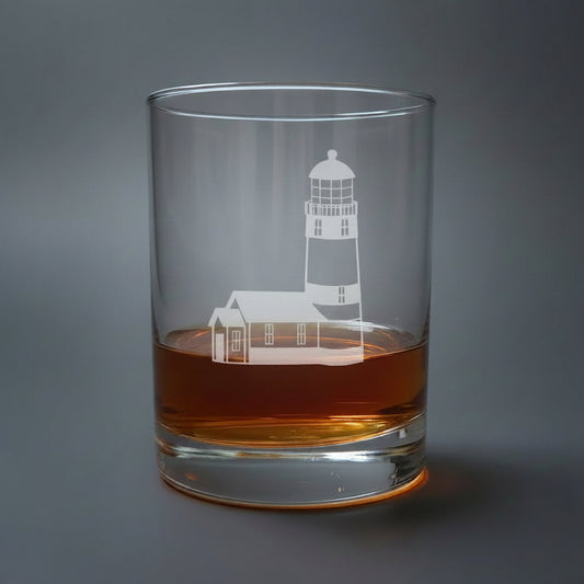 Glass with lighthouse design filled with amber liquid