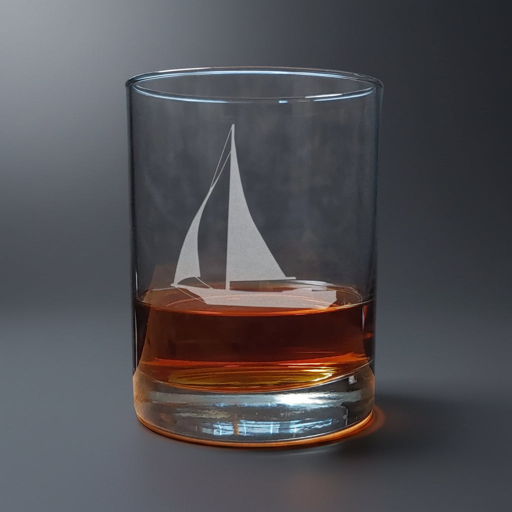 Glass with sailboat etching filled with amber liquid 