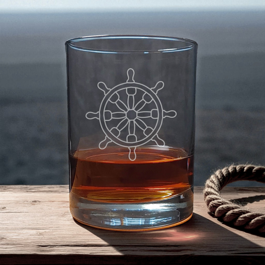 Clear glass with a ship's wheel engraving on a wooden surface with a blurred natural background