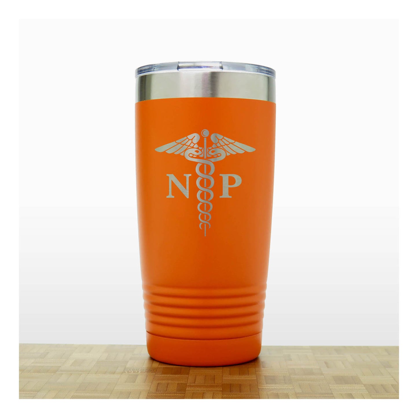 An orange insulated travel tumbler with a stainless steel lid, With an laser engraved  medical caduceus symbol with the letters 'NP' on the front, standing on a wooden surface against a white background.