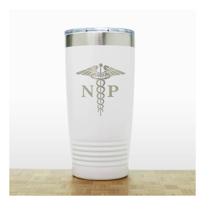 A white insulated travel tumbler with a stainless steel lid, With an laser engraved  medical caduceus symbol with the letters 'NP' on the front. The tumbler is shown standing on a light wood surface against a white background.