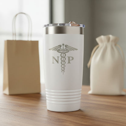 A white insulated travel tumbler with a lid stands on a wooden table. With an laser engraved  medical caduceus symbol with the letters 'NP' on the front