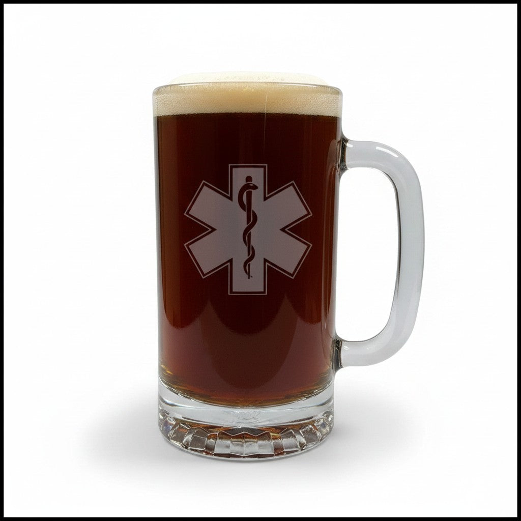 A clear glass beer mug filled with dark brown beer and topped with white foam, featuring a EMS Star of Life with a snake symbol on the front.
