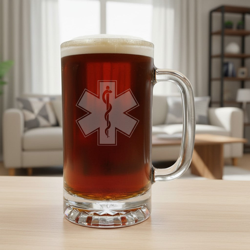 A clear glass beer mug filled with amber beer, featuring a etched EMS Symbol on the front, set on a light wood table in a blurred living room background.