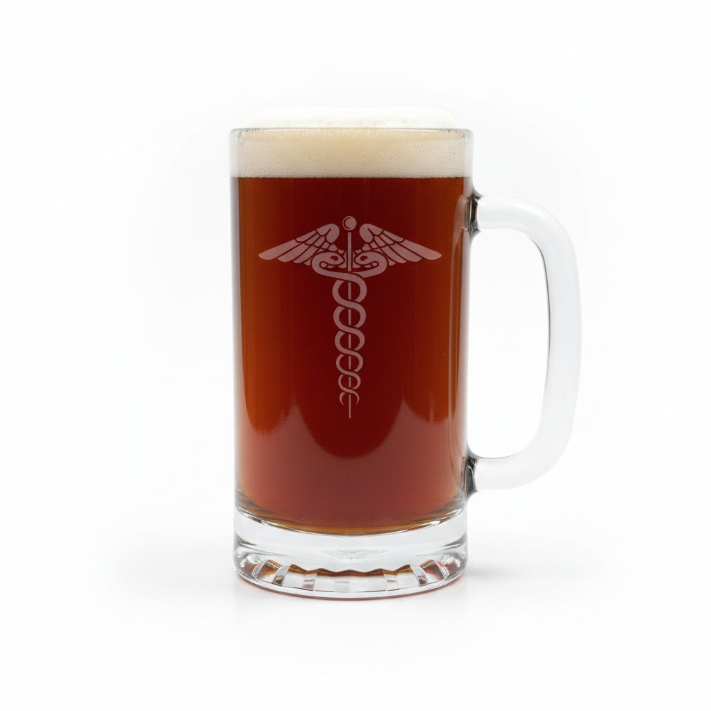 A clear glass beer mug filled with dark amber beer and topped with white foam, featuring an etched medical caduceus symbol on the front, set on a light wood surface against a white background.