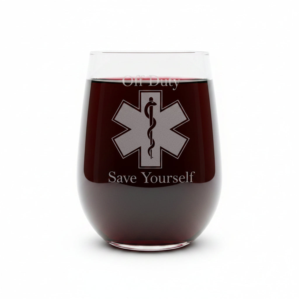 A clear stemless wine glass with a etched EMS symbol with "Off Duty" above the symbolb and "Save Yourself" below. Shown on a white surface against a white background 