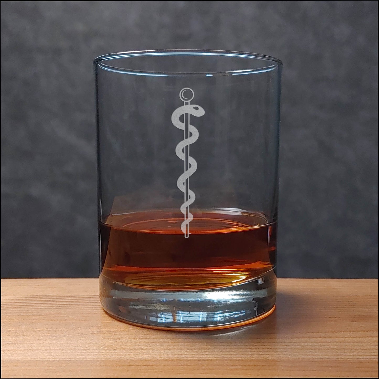 Whiskey Glass with a etched image of a Rod of Asclepius on it - Copyright Hues in Glass
