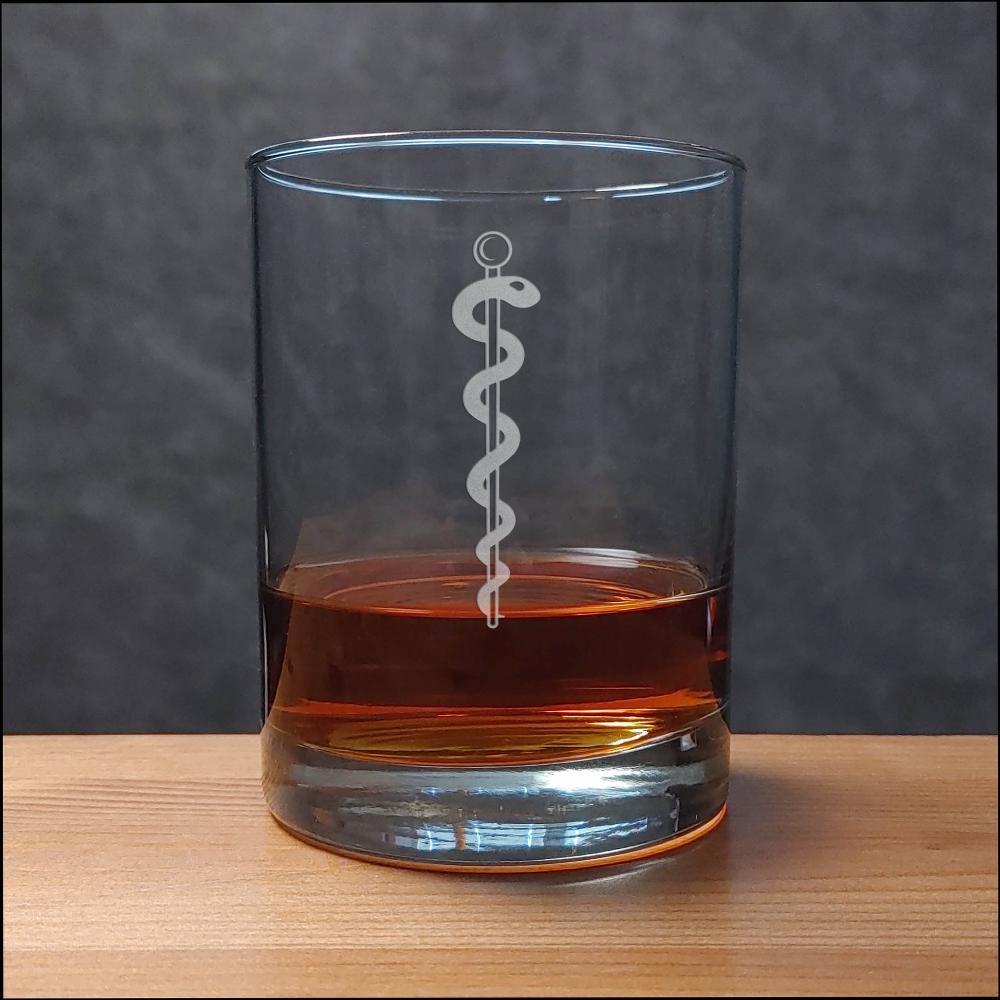 Whiskey Glass with a etched image of a Rod of Asclepius on it - Copyright Hues in Glass