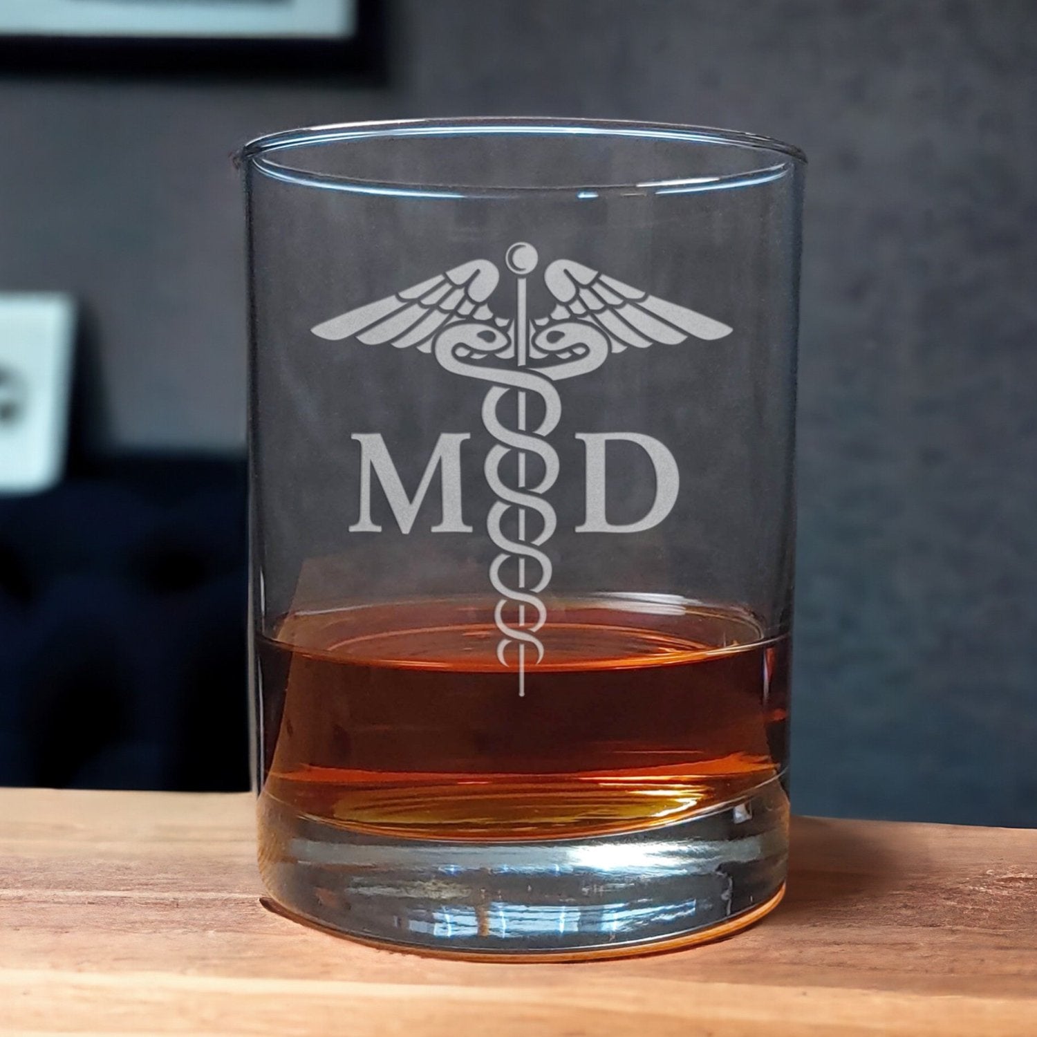 Whiskey Glass with a etched image of a Caduceus and the designation letters M D on either side of it it - Copyright Hues in Glass