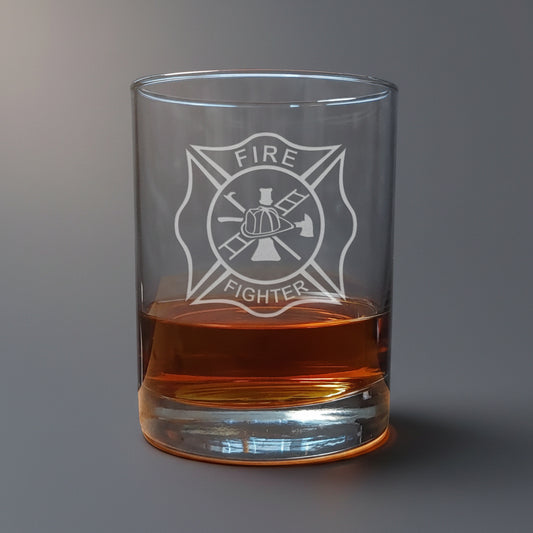 Glass tumbler with 'Fire Fighter' emblem filled with amber liquid