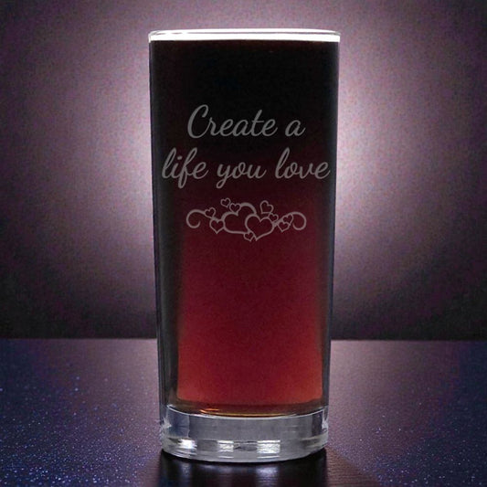 Glass with engraved text and design on a dark background