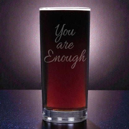 Glass with 'You are Enough' text on a dark background