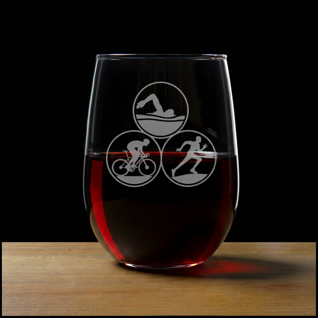 Clear glass with triathlon symbols on a wooden surface and black background