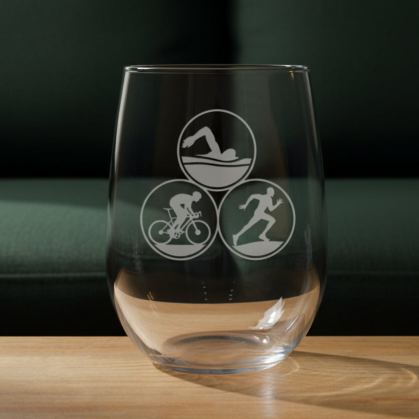 Clear glass with triathlon symbols on a wooden surface