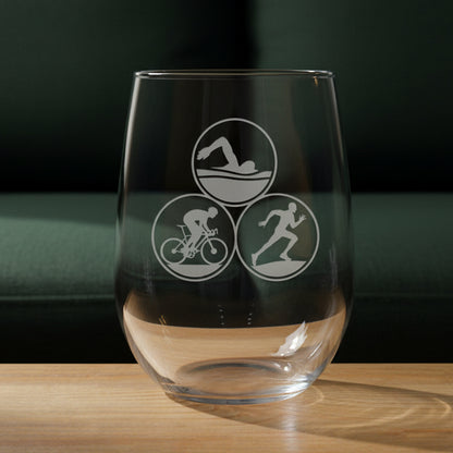 Clear glass with triathlon symbols on a wooden surface