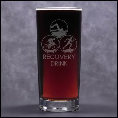 Glass with upper case 'Recovery Drink' text 