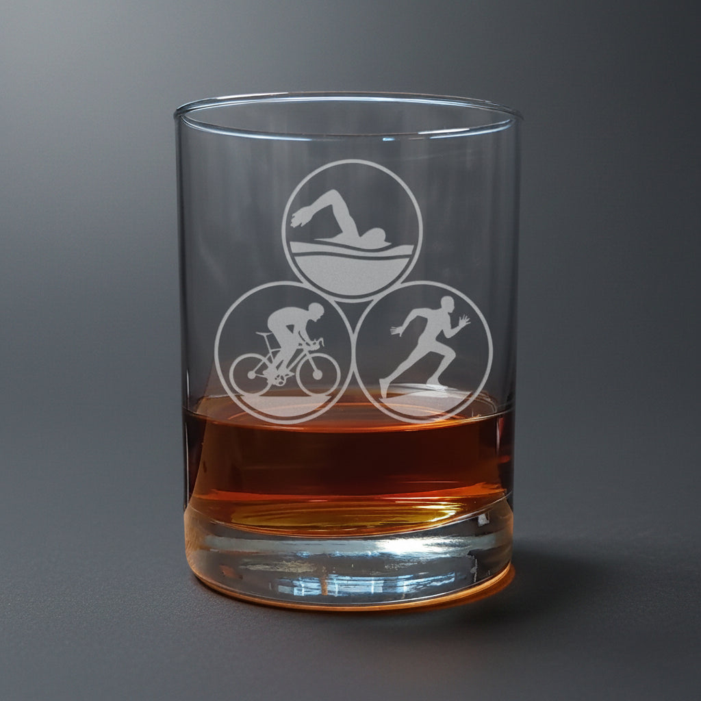 13oz whiskey Glass  with Triathlon symbols filled with a brown liquid on a wooden surface.