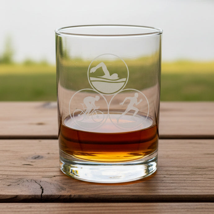 13oz glass tumbler with Triathlon symbols on a wooden surface.