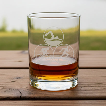 13oz glass tumbler with Triathlon symbols on a wooden surface.