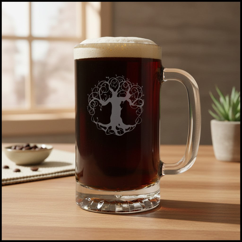 A large clear glass beer mug filled with dark beer and topped with foam, standing on a wooden table. The mug has a frosted tree-of-life design on the front.