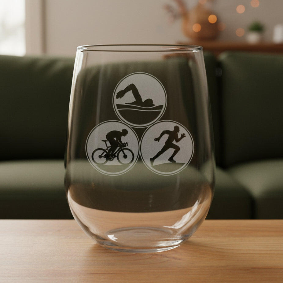 Clear glass with triathlon symbols on a wooden surface