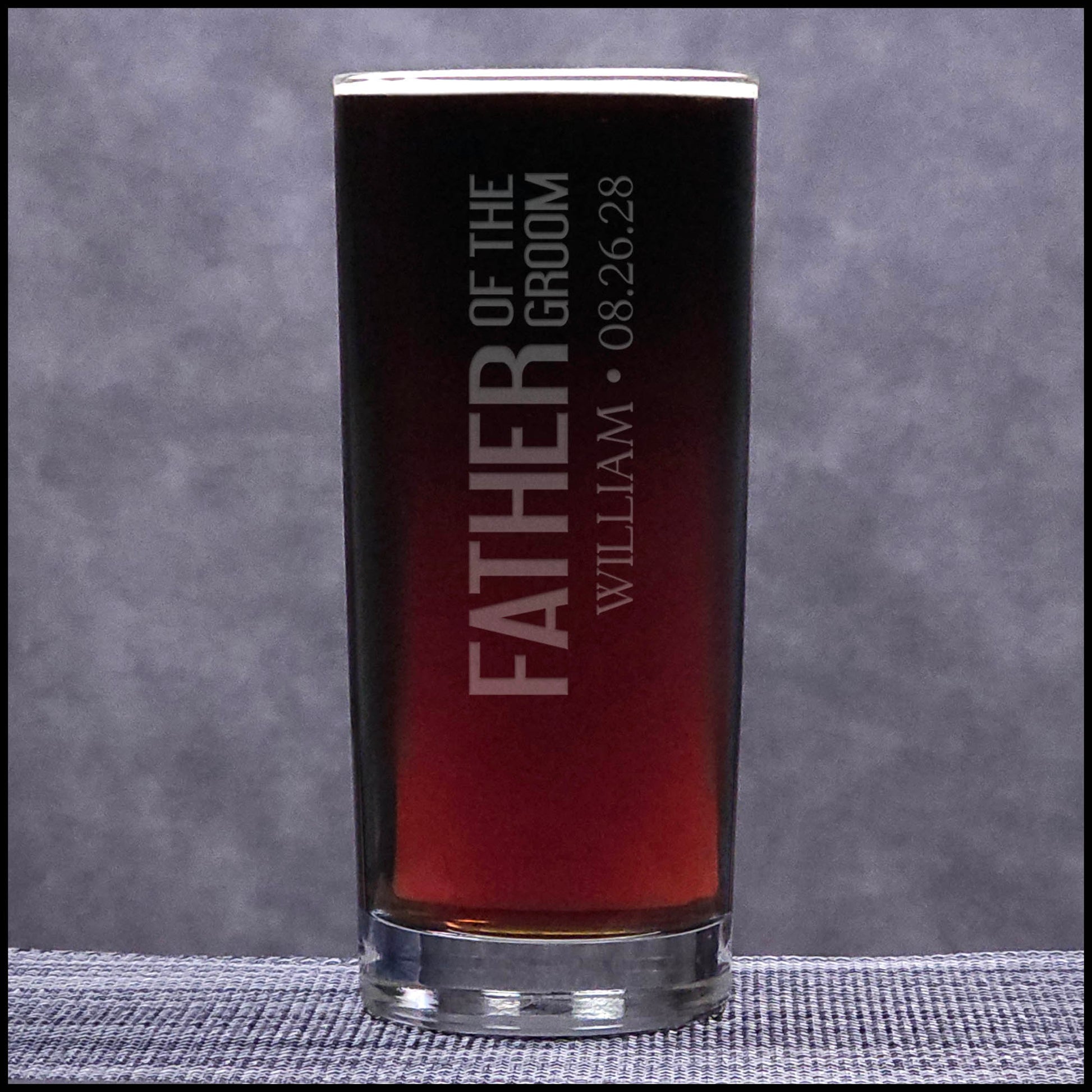 Personalized glass with engraved text on a gray background