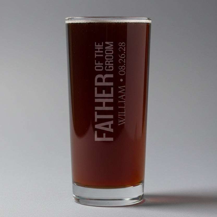 Pint glass with 'Father of the Groom' engraving on a gray background
