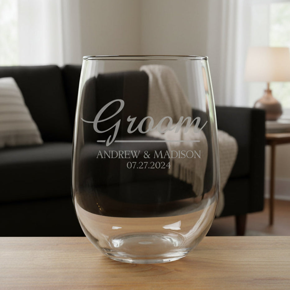 Clear glass stemless wine glass with engraved text on a wooden surface 