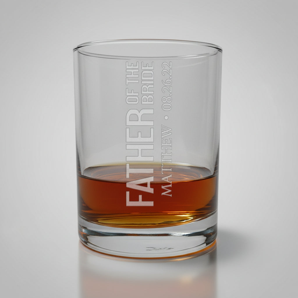 Glass tumbler with engraved text on a wooden surface and gray background