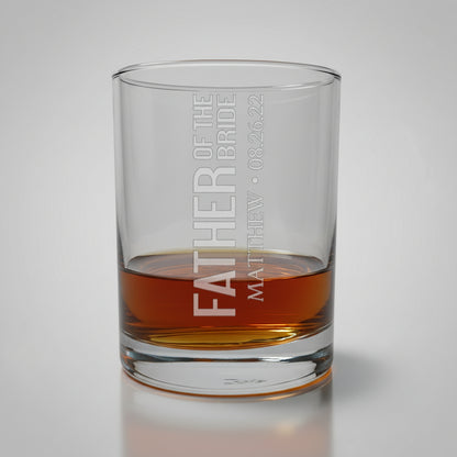 Glass tumbler with engraved text on a wooden surface and gray background