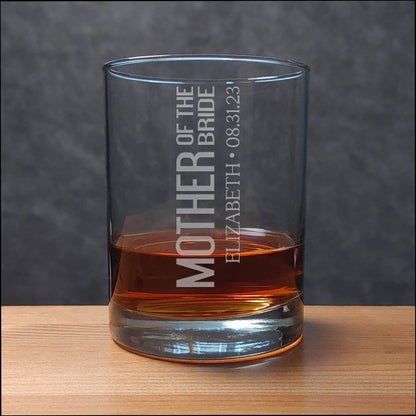 Glass tumbler with engraved text on a wooden surface and gray background