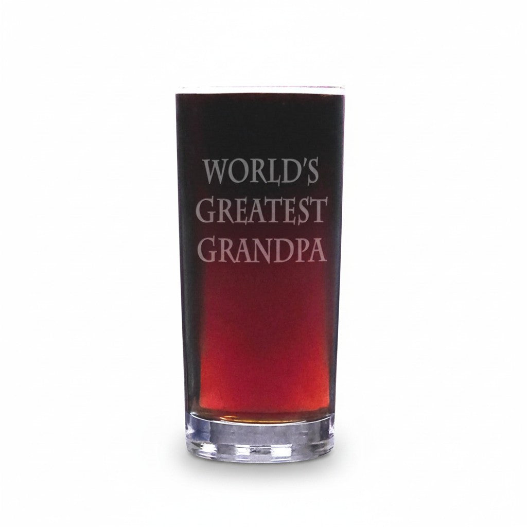 A tall, slender cooler glass with the phrase 'WORLD'S GREATEST GRANDPA' etched on a it, shown against a plain white studio background.