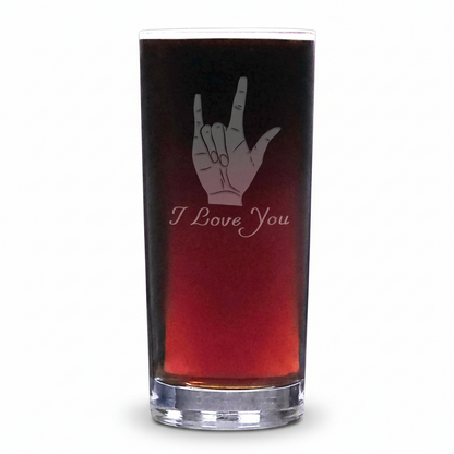 A clear cooler glass filled with a dark red drink, featuring an etched ASL hand gesture and the words 'I Love You' on the front, set against a plain white background.